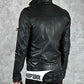 Black leather jacket with visible branding on a gray background