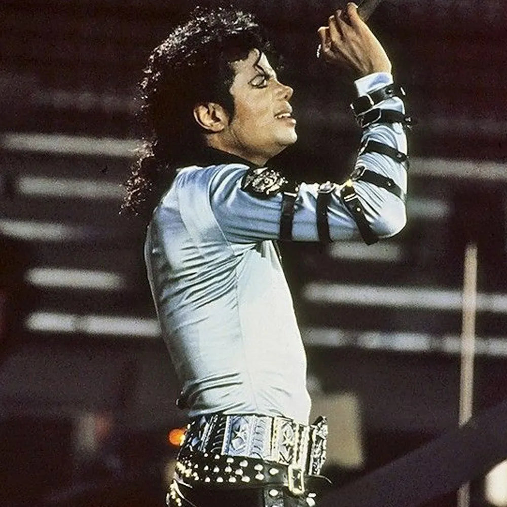 Person in a light blue outfit with studded details, performing on stage.