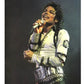 Person in a white jacket with black accents holding a microphone against a dark background
