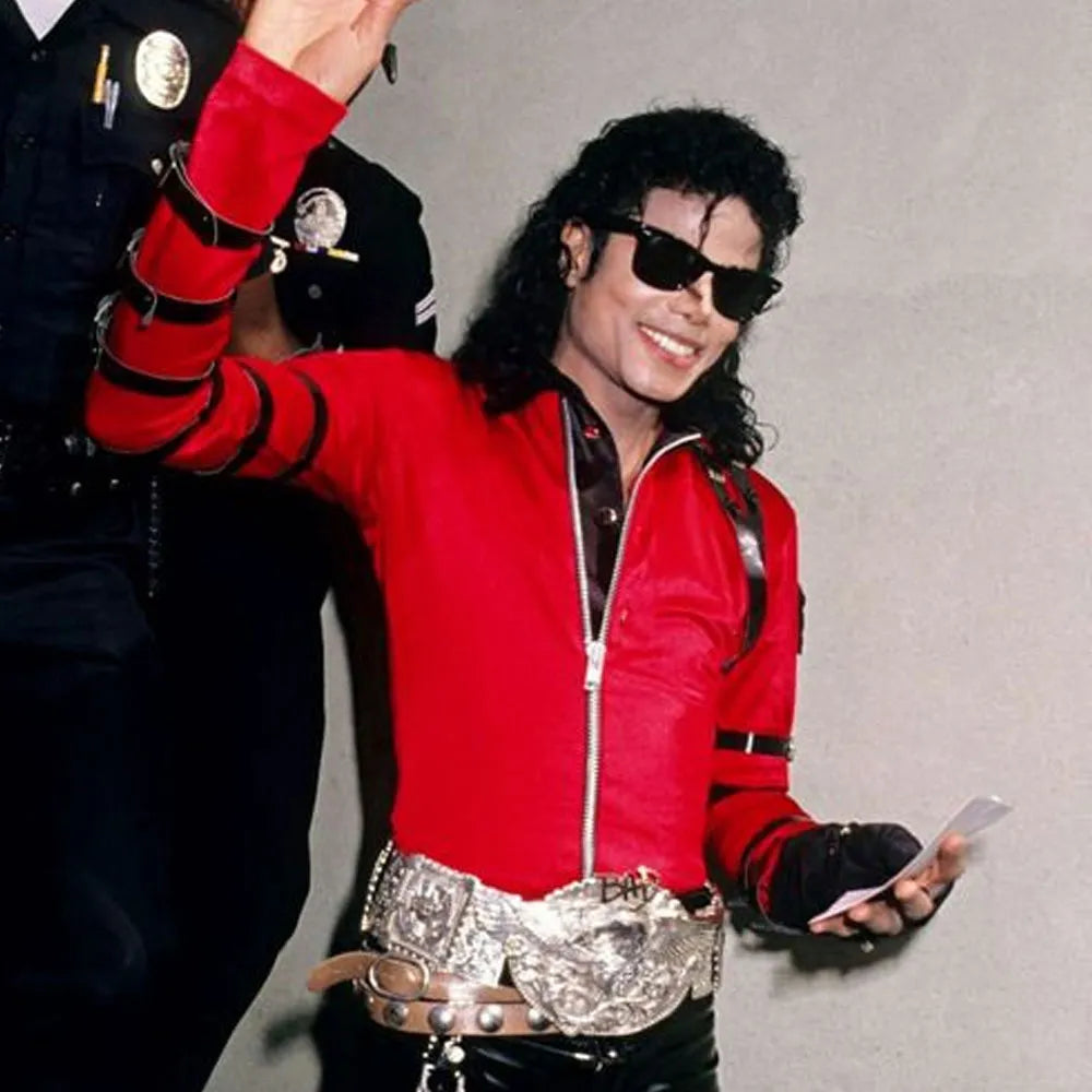Person wearing a red jacket with black accents, holding a phone, on a plain background