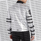 Person wearing a white hoodie with black stripes and text on a background with 'Urban Collections' branding.
