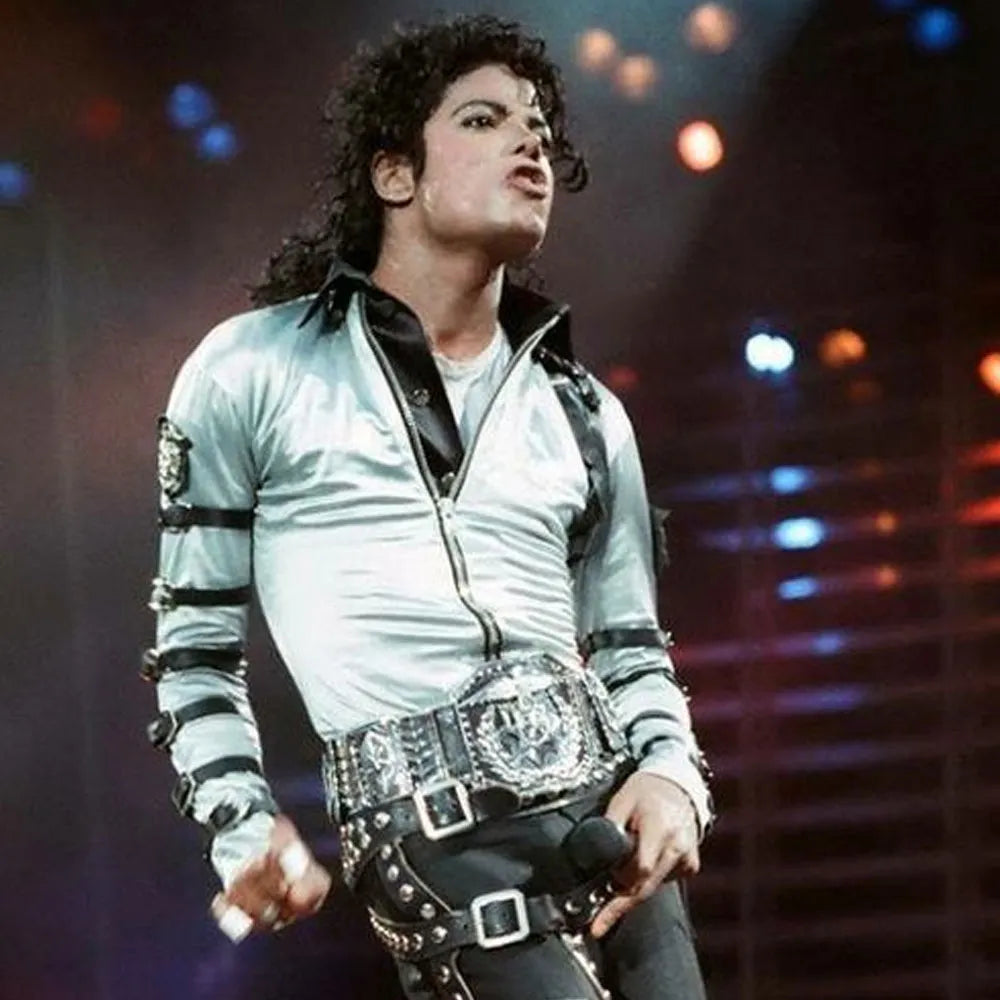 Person wearing a silver jacket with black accents on stage